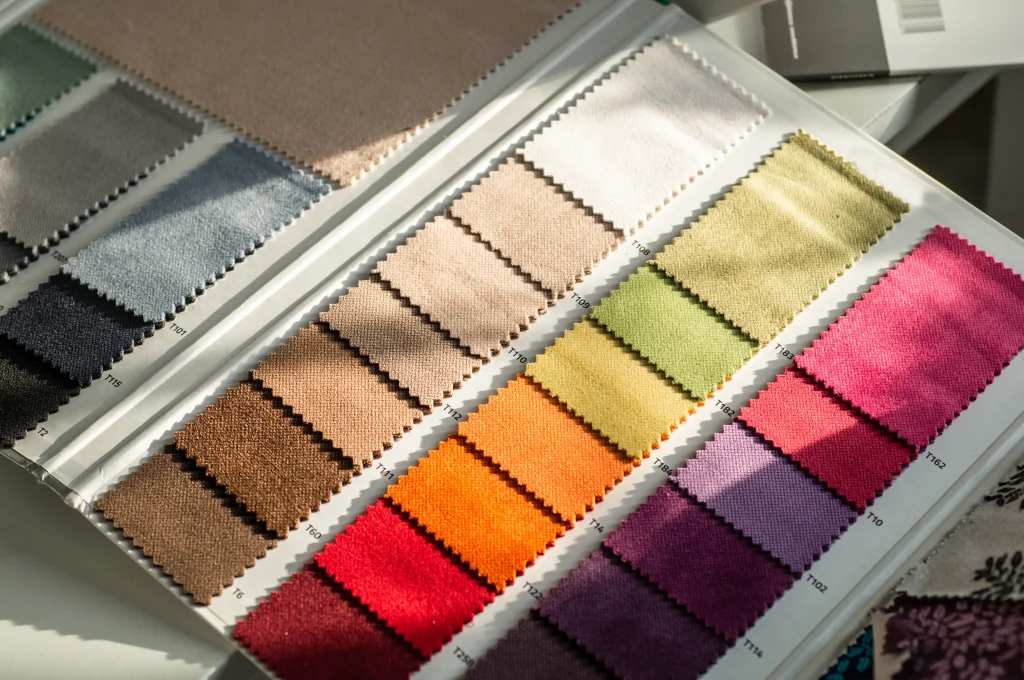 Sara Sourcing team matching printed fabric samples with Pantone color swatches for consistency.