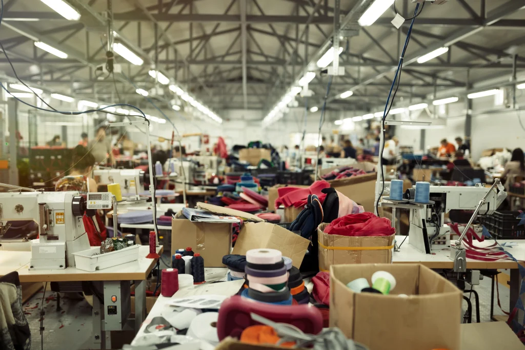 Skilled garment workers operating industrial sewing machines in a high-capacity apparel manufacturing unit.